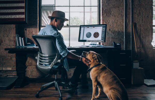 a-man-and-a-dog-sitting-in-front-of-a-computer