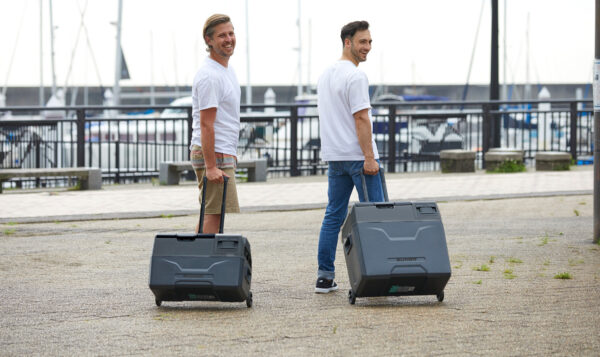 two-men-carrying-a-portable-refrigerator