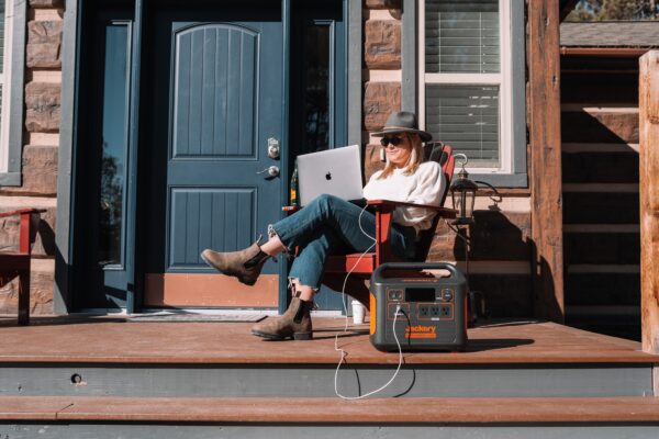 a-person-charging-a-computer-from-a-portable-power-source