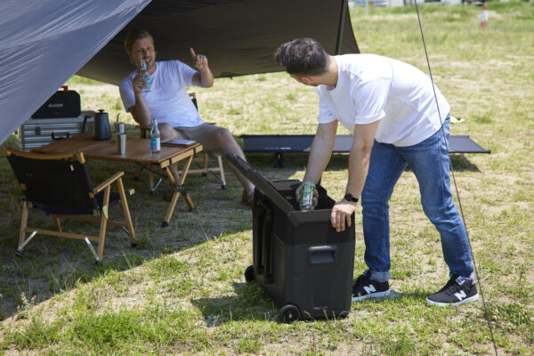 a-man-who-takes-drinks-out-of-a-portable-refrigerator