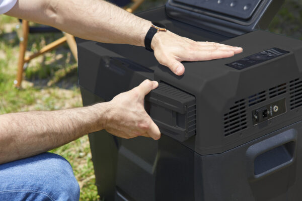 a-man-who-removes-batteries-from-a-portable-refrigerator